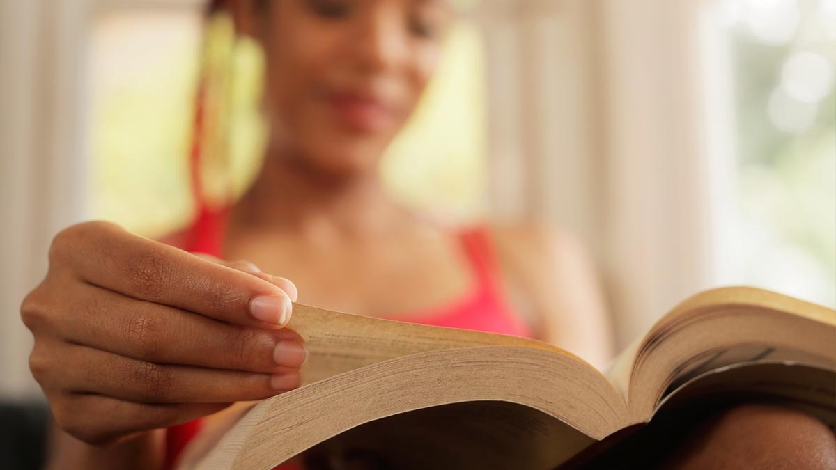 A young woman reads a book