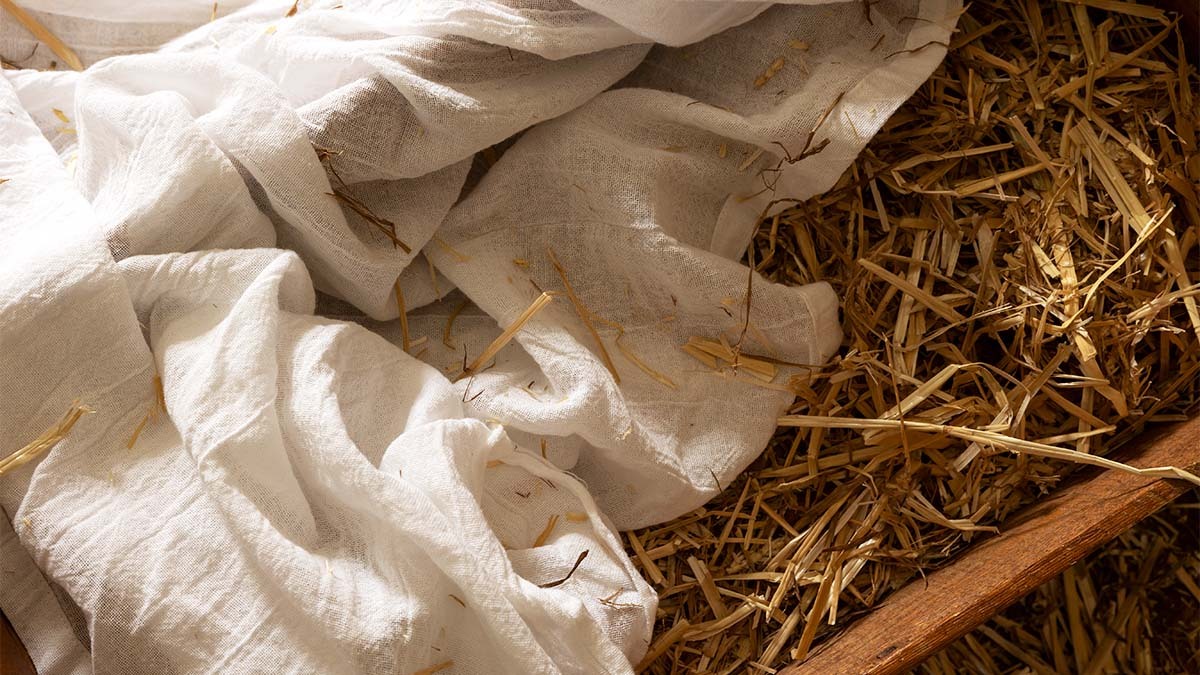 An empty manger filled with straw and white cloth