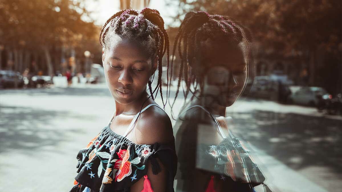 A girl looks at her reflection in a window