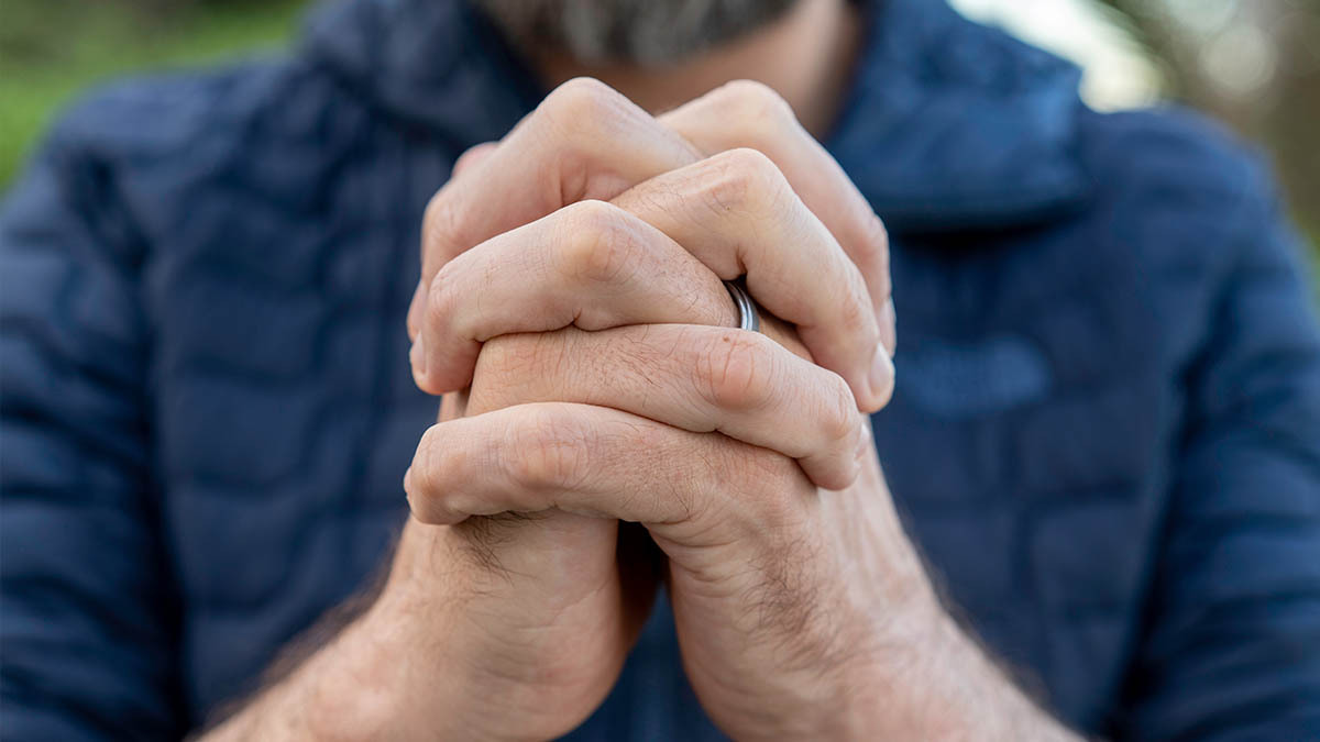 A man folds his hands to pray
