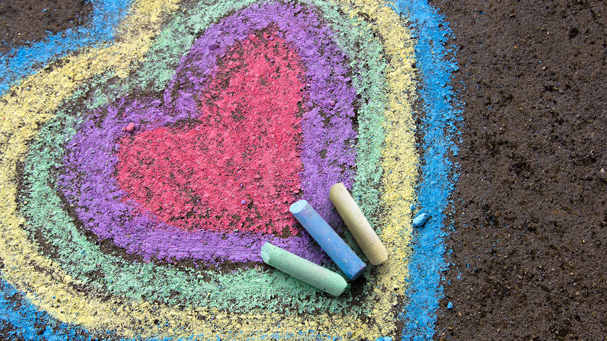 A heart drawn on pavement by three pieces of chalk