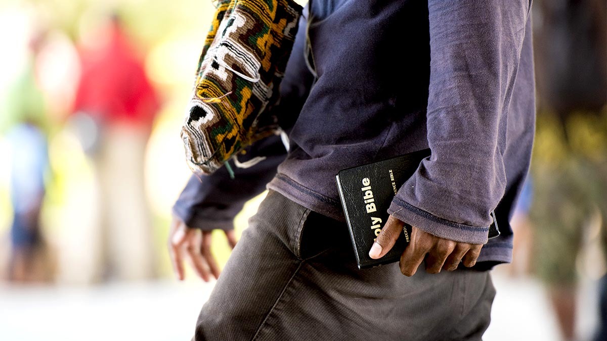 A man walks around in public with a Bible in his hand
