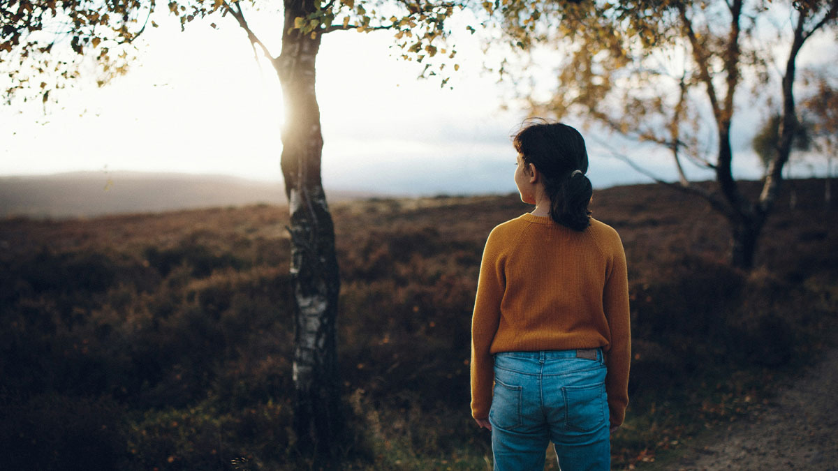 A young woman loking at the sun