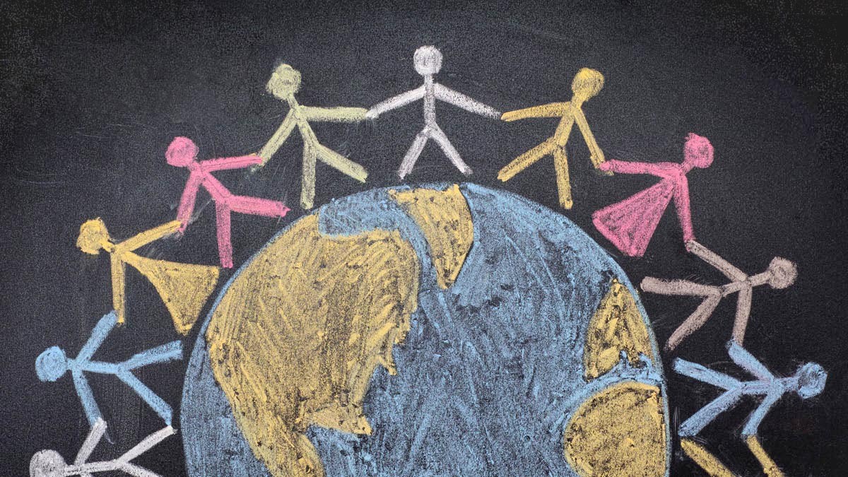 A chalk drawing of people around the world holding hands