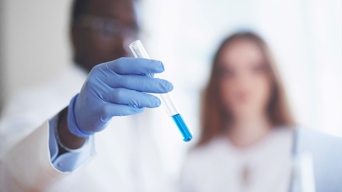 A scientist holds a test tube in a lab