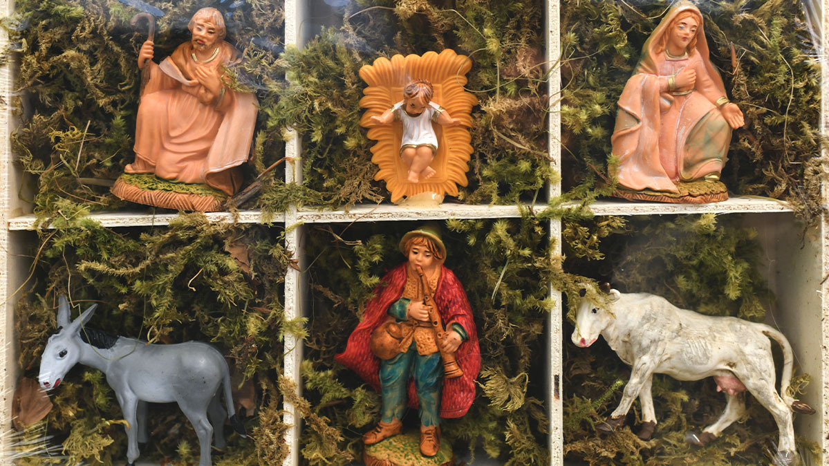 Baby Jesus, Mary, Joseph, and other Christmas Nativity figurines sit in a box