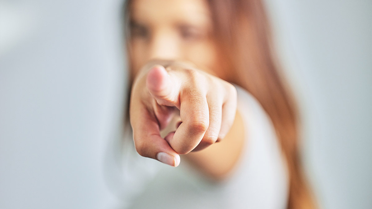 A woman points her finger at the camera