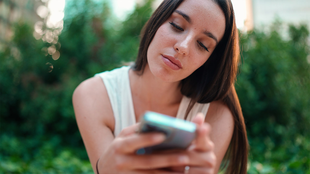 A young woman scrolls through social media on her phone