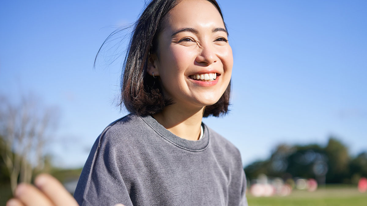 A young woman smiling with the sun shining on her face