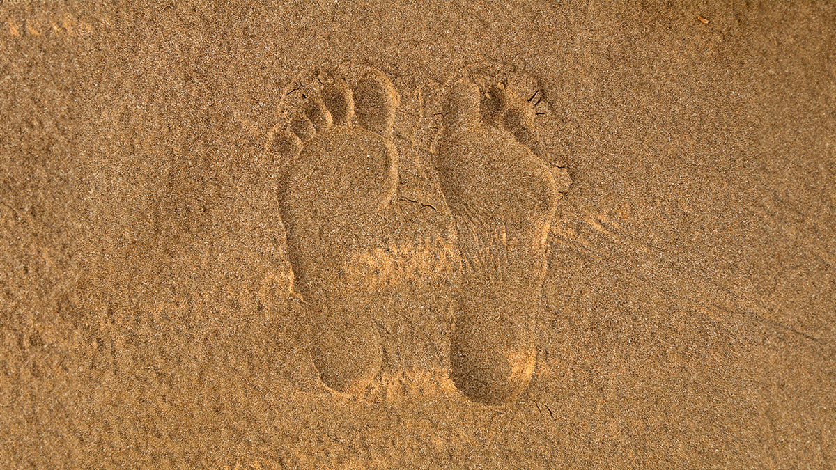 Two footprints from a man are in the sand