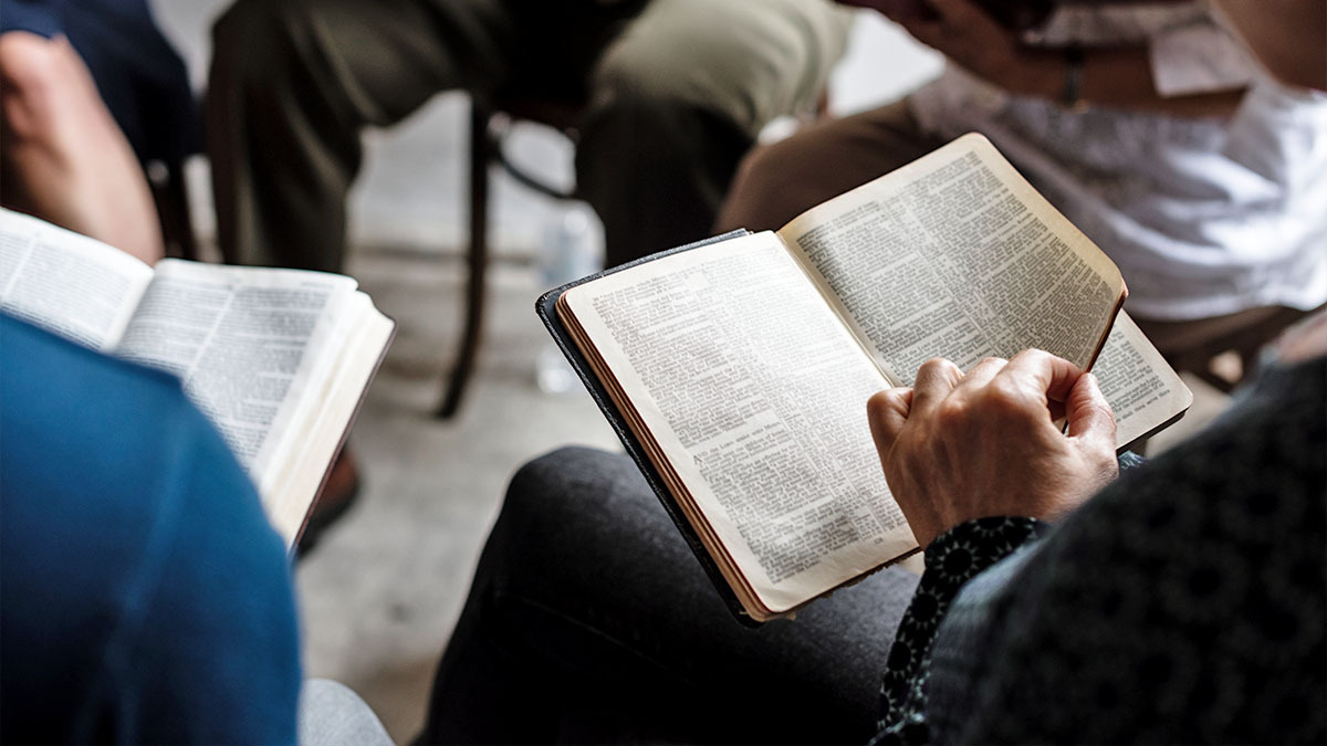 A woman turns a page in her Bible