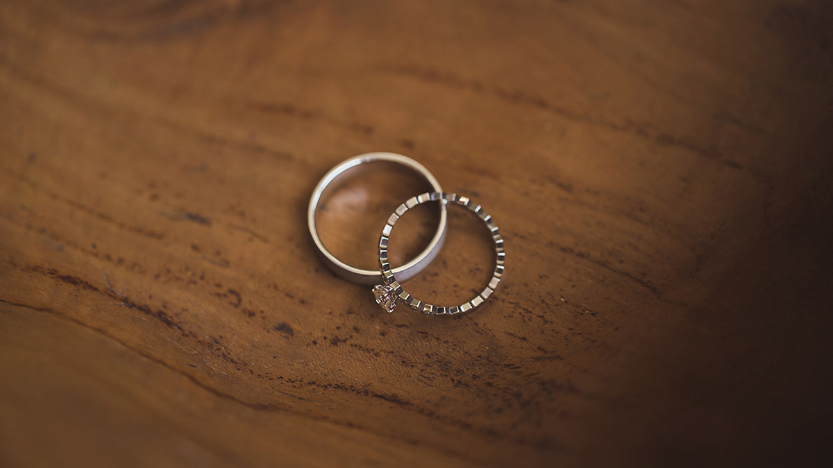 Two wedding rings sitting on a wooden background