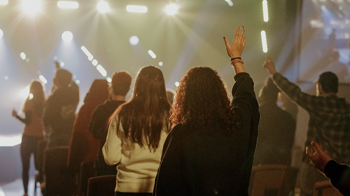 Members of a church sing and lift their hands in worship