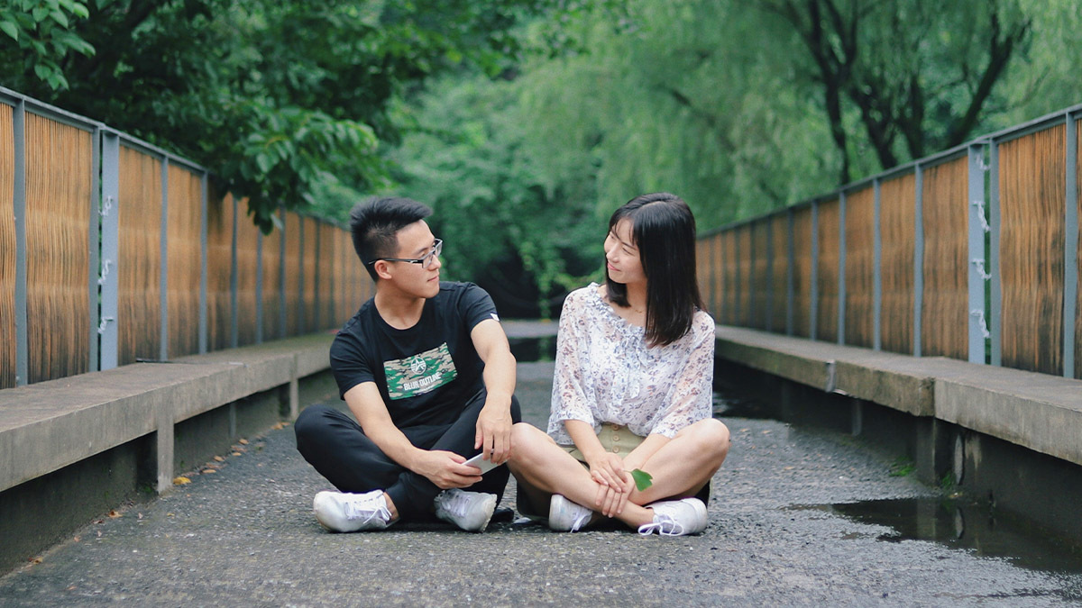 A young couple sit down and look at each other