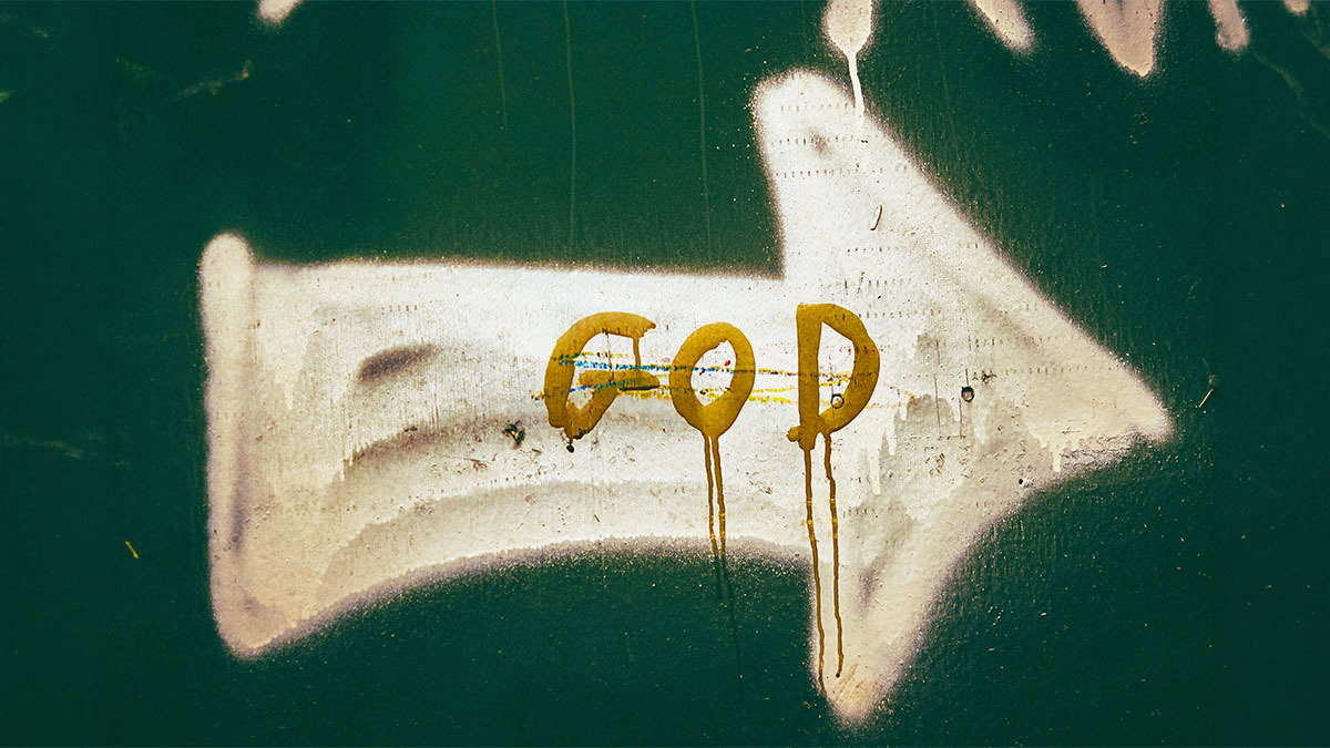 A graffiti arrow with the word "God" painted over top